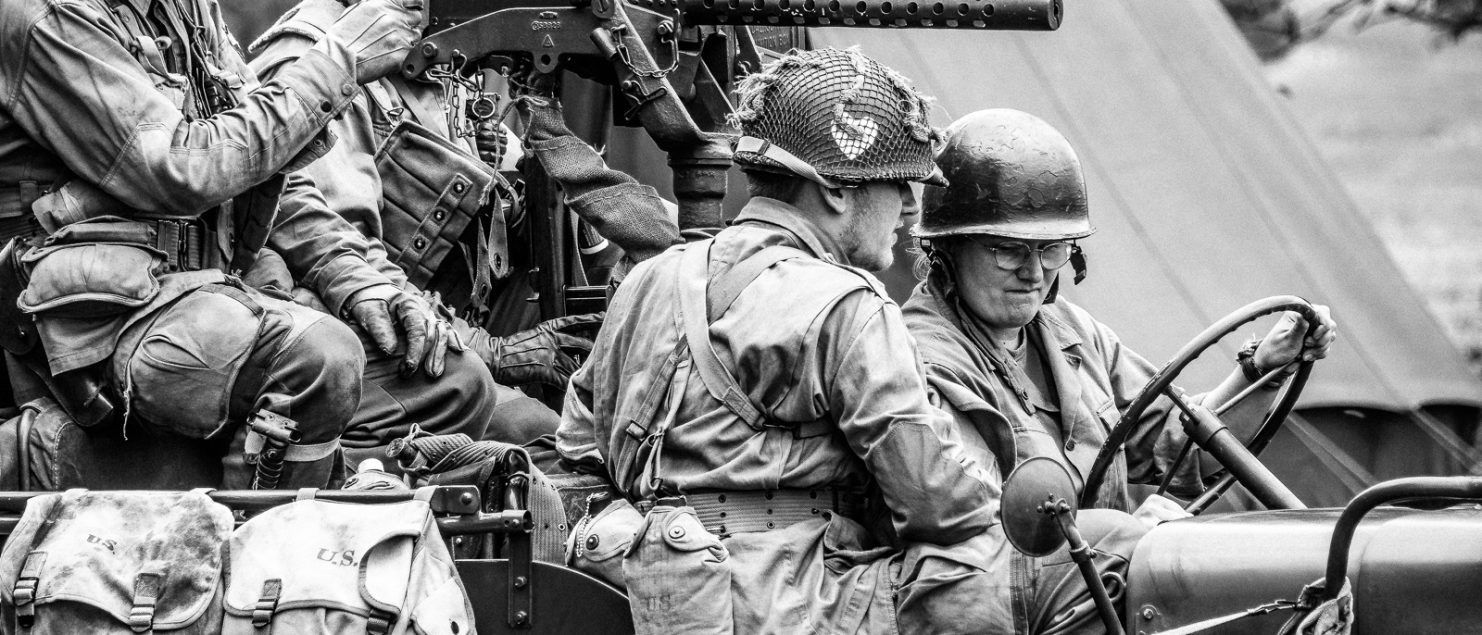 Four World War II Re-Enactors in Jeep